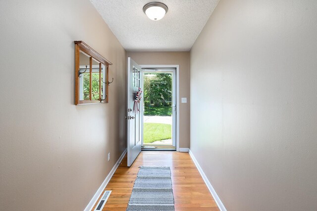 1704 E Latoka St, Springfield, MO 65804 - doorway to outside with a textured ceiling and light wood finished floors