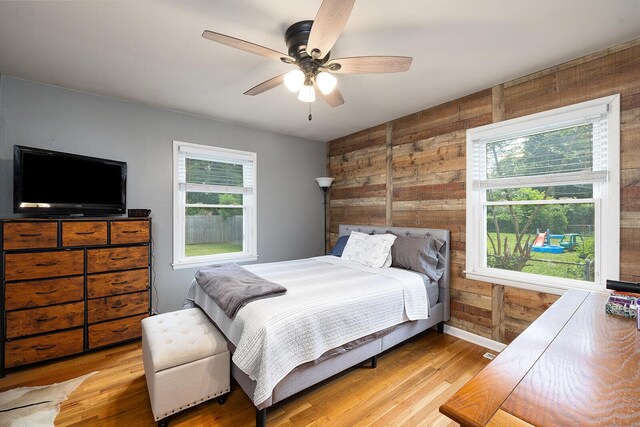 1704 E Latoka St, Springfield, MO 65804 - bedroom with multiple windows, wooden walls, wood finished floors, and ceiling fan