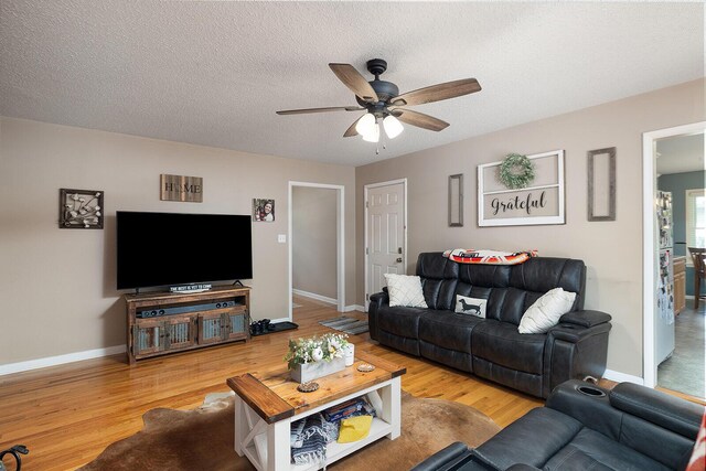 1704 E Latoka St, Springfield, MO 65804 - living room featuring a ceiling fan, wood finished floors, and a textured ceiling