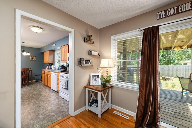1704 E Latoka St, Springfield, MO 65804 - kitchen with white appliances, a chandelier, and light wood-type flooring