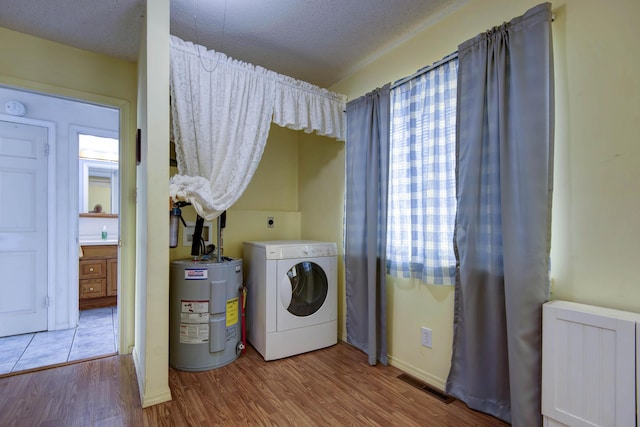 730 Peebles Point Rd, Cape Fair, MO 65624 - laundry area with washer / dryer, radiator, water heater, wood finished floors, and a textured ceiling