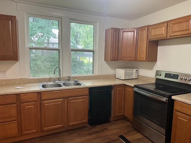 514 N Joplin Ave, Joplin, MO 64801 - kitchen with stainless steel range with electric stovetop, dishwasher, white microwave, dark wood-style floors, and light countertops