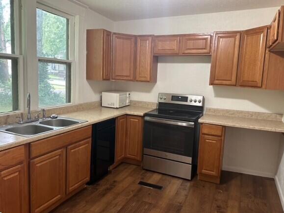 514 N Joplin Ave, Joplin, MO 64801 - kitchen with stainless steel electric stove, black dishwasher, plenty of natural light, and dark wood-style flooring
