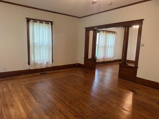 514 N Joplin Ave, Joplin, MO 64801 - empty room featuring ornate columns, ornamental molding, and hardwood / wood-style flooring