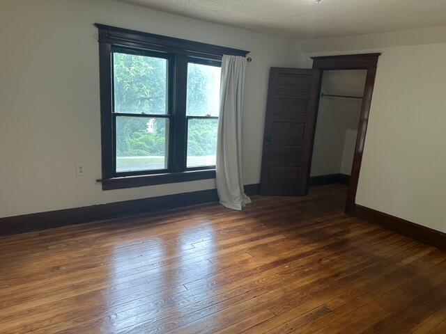 514 N Joplin Ave, Joplin, MO 64801 - unfurnished bedroom with multiple windows, hardwood / wood-style flooring, and a closet