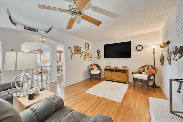 29 Trail Ridge Dr, Kimberling City, MO 65686 - living area with arched walkways, ceiling fan, light wood-style flooring, and a textured ceiling