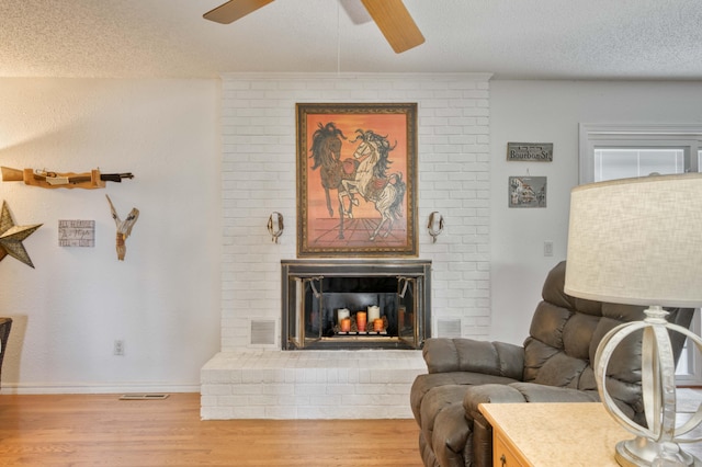 29 Trail Ridge Dr, Kimberling City, MO 65686 - living room featuring wood finished floors, ceiling fan, a textured ceiling, and a brick fireplace