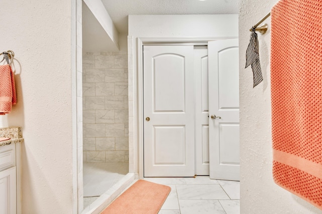 29 Trail Ridge Dr, Kimberling City, MO 65686 - full bathroom with marble look tile flooring, a tile shower, and a textured wall
