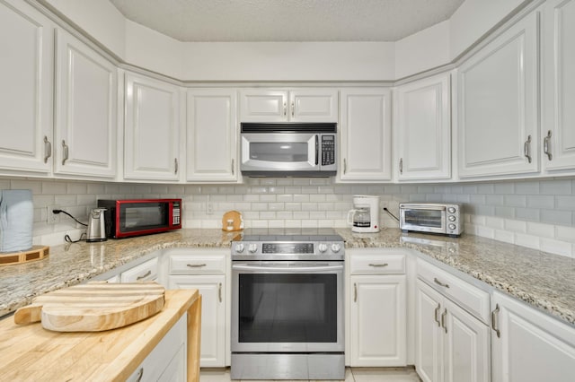 29 Trail Ridge Dr, Kimberling City, MO 65686 - kitchen with appliances with stainless steel finishes, white cabinets, tasteful backsplash, a textured ceiling, and light stone countertops
