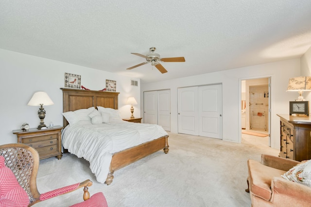 29 Trail Ridge Dr, Kimberling City, MO 65686 - bedroom featuring multiple closets, light colored carpet, connected bathroom, ceiling fan, and a textured ceiling