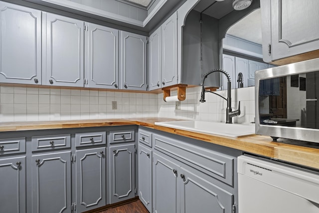 716 S Rogers Ave, Springfield, MO 65804 - kitchen with wooden counters, dishwashing machine, gray cabinetry, tasteful backsplash, and stainless steel microwave