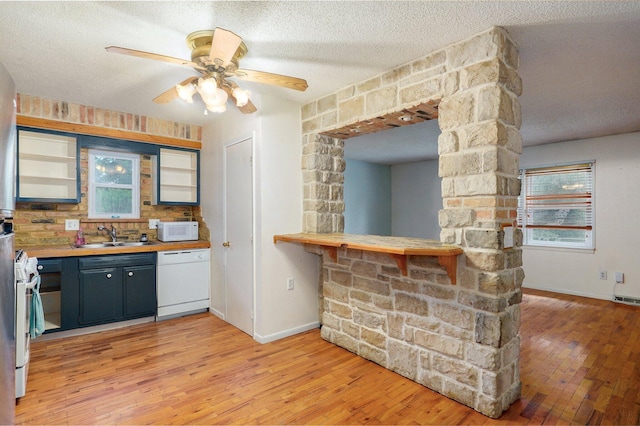 1111 S Lone Pine Ave, Springfield, MO 65804 - kitchen with white appliances, light wood-type flooring, a textured ceiling, and ceiling fan