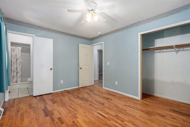 1111 S Lone Pine Ave, Springfield, MO 65804 - unfurnished bedroom featuring wood finished floors, a textured ceiling, a closet, ensuite bath, and a ceiling fan