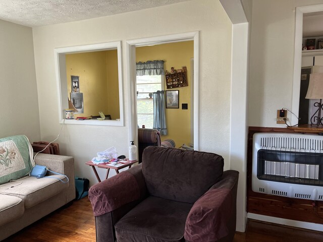 424 W Park St, Seymour, MO 65746 - living area featuring heating unit, wood finished floors, and a textured ceiling