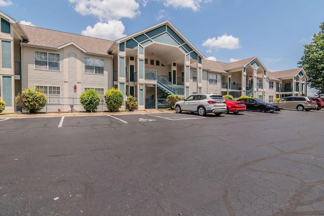 120 Spring Creek Ct Unit B1-U19, Branson, MO 65616 - view of building exterior with uncovered parking, stairs, and a residential view