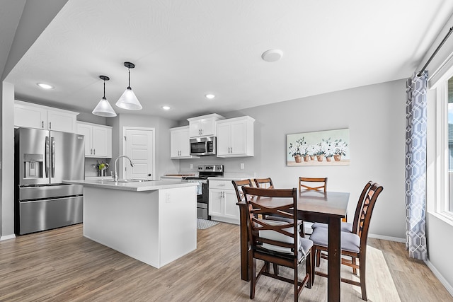 3891 N Spring Branch Ave, Springfield, MO 65803 - kitchen with stainless steel appliances, light countertops, light wood-style floors, white cabinetry, and recessed lighting