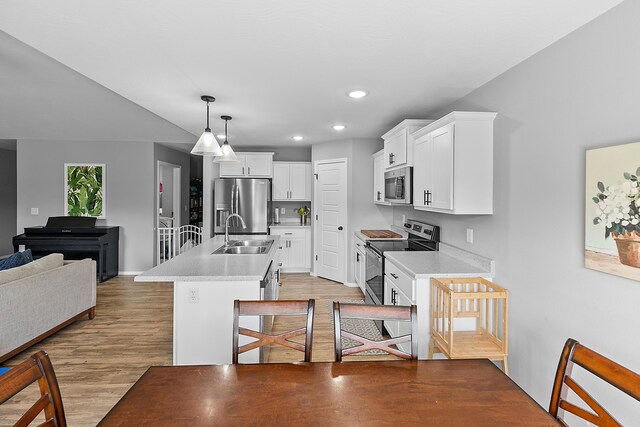 3891 N Spring Branch Ave, Springfield, MO 65803 - kitchen with appliances with stainless steel finishes, light countertops, light wood-style floors, white cabinets, and decorative light fixtures