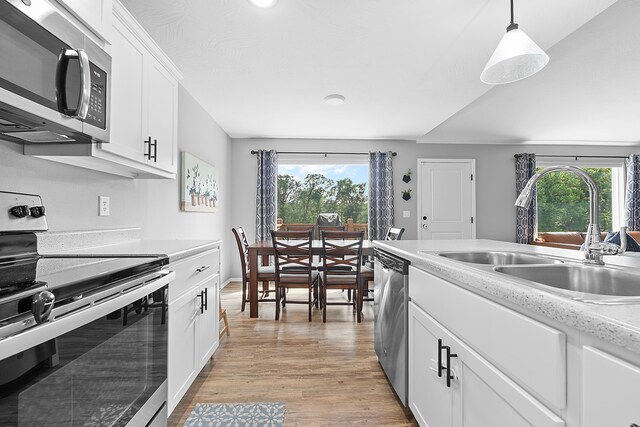 3891 N Spring Branch Ave, Springfield, MO 65803 - kitchen featuring stainless steel appliances, light countertops, light wood-style flooring, white cabinets, and hanging light fixtures