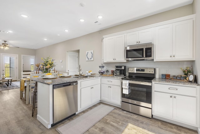 3011 N Vineyards Terrace Parkway Unit 1, 2, 3, 4, Branson, MO 65616 - kitchen featuring appliances with stainless steel finishes, a peninsula, white cabinetry, light wood-type flooring, and recessed lighting