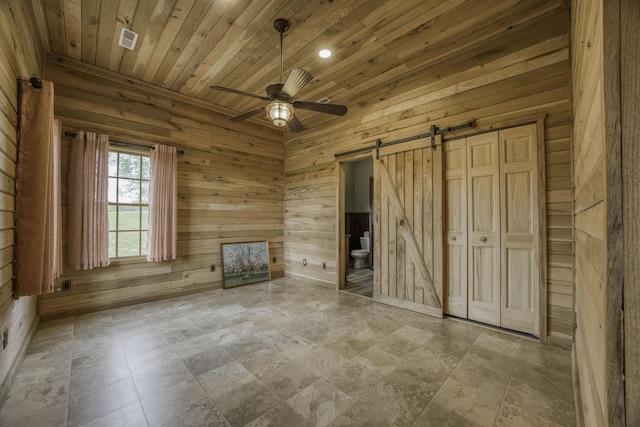12132 W Farm Road 18, Walnut Grove, MO 65770 - unfurnished bedroom featuring a barn door, wooden ceiling, wood walls, ensuite bathroom, and recessed lighting