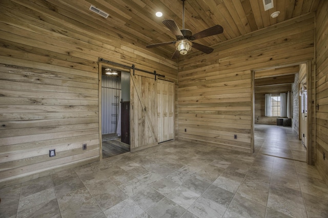 12132 W Farm Road 18, Walnut Grove, MO 65770 - unfurnished bedroom with a barn door, wood walls, wooden ceiling, stone finish floors, and ceiling fan