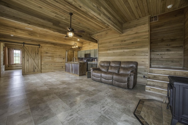 12132 W Farm Road 18, Walnut Grove, MO 65770 - living room featuring wooden walls, a ceiling fan, a barn door, and a wooden ceiling with exposed beams