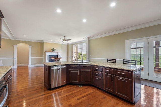 358 Spring View Pl, Reeds Spring, MO 65737 - kitchen featuring stainless steel dishwasher, ornate columns, a ceiling fan, a warm lit fireplace, and ornamental molding