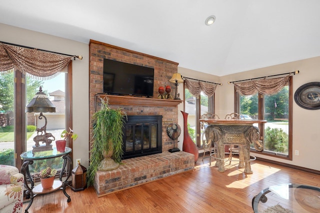 3141 E Raynell St Unit D, Springfield, MO 65804 - living area with plenty of natural light, wood finished floors, vaulted ceiling, and a brick fireplace