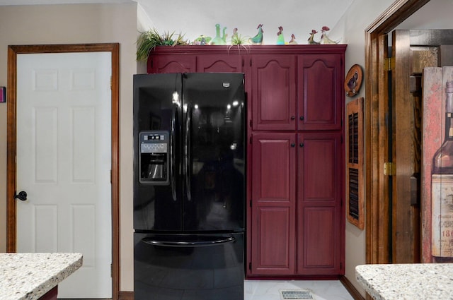 3141 E Raynell St Unit D, Springfield, MO 65804 - kitchen featuring black fridge, reddish brown cabinets, and light stone counters