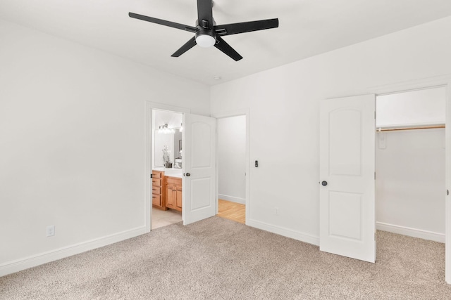 1303 E Eaglegate Pkwy, Springfield, MO 65804 - unfurnished bedroom featuring light colored carpet, a walk in closet, a closet, ensuite bath, and a ceiling fan