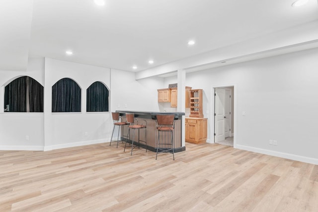 1303 E Eaglegate Pkwy, Springfield, MO 65804 - kitchen featuring a kitchen bar, light wood-style floors, light brown cabinets, recessed lighting, and a peninsula