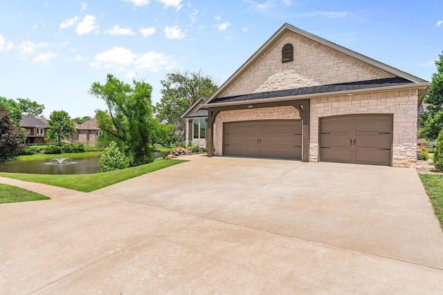 1303 E Eaglegate Pkwy, Springfield, MO 65804 - french country style house with stone siding, driveway, a water view, and an attached garage