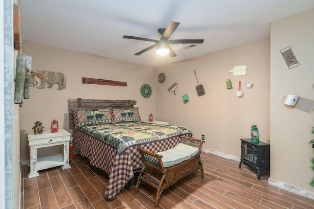 10626 W State Highway 76, Cape Fair, MO 65624 - bedroom featuring wood finish floors, a wood stove, and a ceiling fan