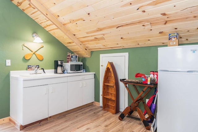 10626 W State Highway 76, Cape Fair, MO 65624 - kitchen featuring freestanding refrigerator, wood ceiling, stainless steel microwave, light wood-type flooring, and white cabinetry