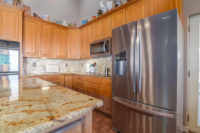 10626 W State Highway 76, Cape Fair, MO 65624 - kitchen featuring appliances with stainless steel finishes, decorative backsplash, light stone countertops, and brown cabinets