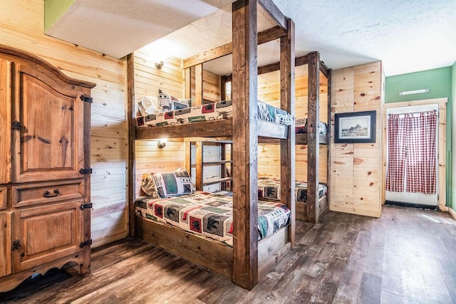 10626 W State Highway 76, Cape Fair, MO 65624 - bedroom with wood walls, dark wood-style flooring, and a textured ceiling