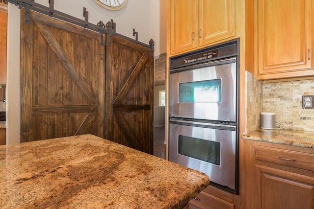 10626 W State Highway 76, Cape Fair, MO 65624 - kitchen featuring double oven, backsplash, light stone countertops, and a barn door