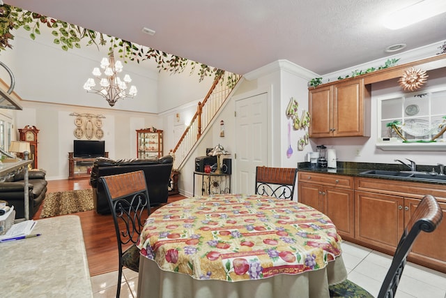 180 Grace Chapel Rd Unit 325, Blue Eye, MO 65611 - dining area with stairway, a chandelier, light tile patterned floors, and a textured ceiling
