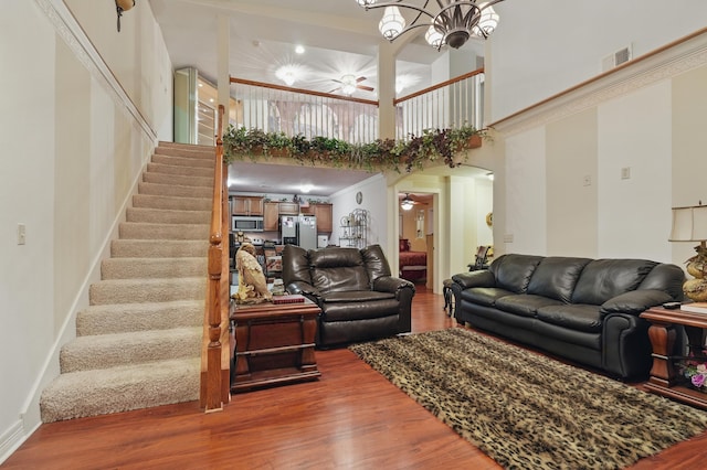 180 Grace Chapel Rd Unit 325, Blue Eye, MO 65611 - living room with a high ceiling, wood finished floors, stairs, a chandelier, and arched walkways