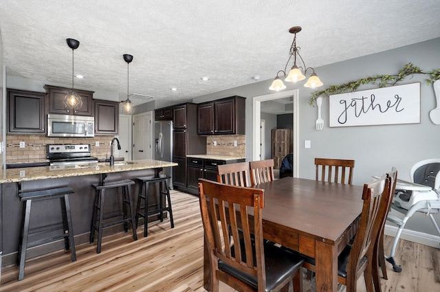 4531 W Somerset Dr, Battlefield, MO 65619 - dining area with light wood-style flooring and a textured ceiling