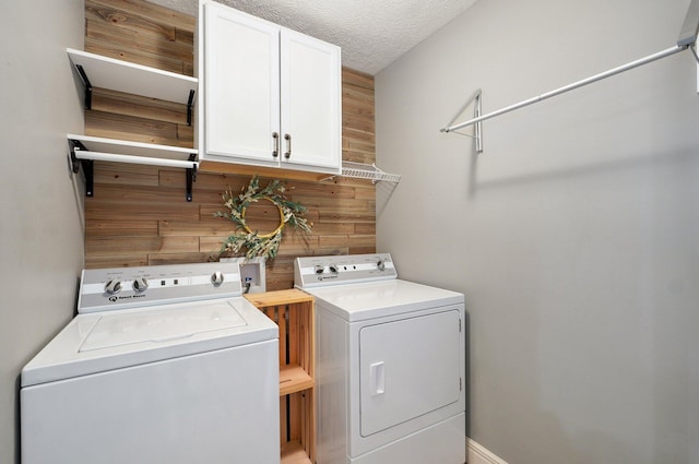 4531 W Somerset Dr, Battlefield, MO 65619 - washroom with washing machine and clothes dryer, cabinet space, wood walls, and a textured ceiling
