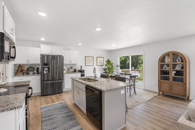 202 N Cheyenne Valley Rd, Nixa, MO 65714 - kitchen with black appliances, backsplash, light wood-type flooring, light stone counters, and white cabinetry