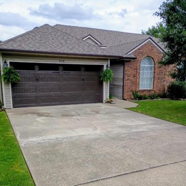315 Buckingham Dr, Branson, MO 65616 - ranch-style house with an attached garage, driveway, roof with shingles, and a front yard