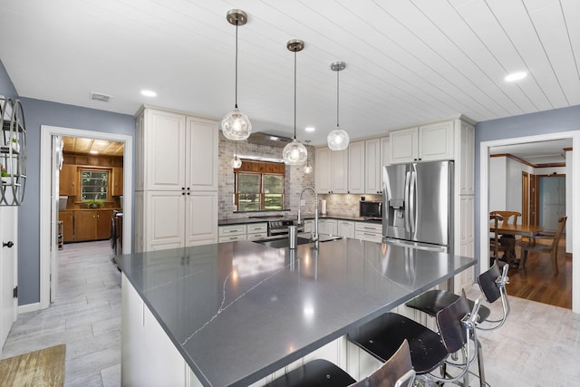 1471 E Bennett St, Springfield, MO 65804 - kitchen with stainless steel appliances, dark countertops, light wood-type flooring, recessed lighting, and decorative light fixtures
