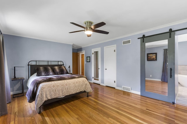 1471 E Bennett St, Springfield, MO 65804 - bedroom with a barn door, wood finished floors, crown molding, and a ceiling fan