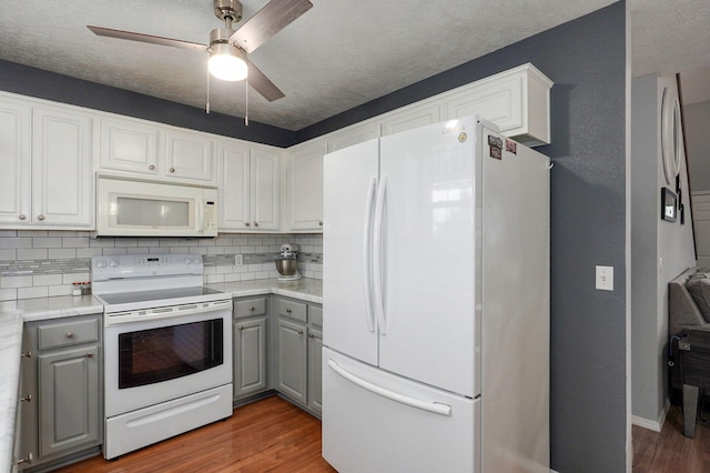 801 S Creekwood Ct, Nixa, MO 65714 - kitchen featuring white appliances, gray cabinetry, wood finished floors, decorative backsplash, and a ceiling fan