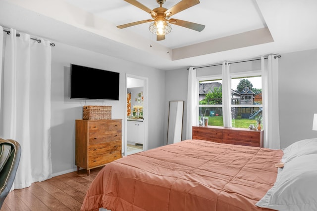 676 E Gallup Hill Rd, Nixa, MO 65714 - bedroom with a tray ceiling, hardwood / wood-style flooring, ensuite bathroom, and ceiling fan