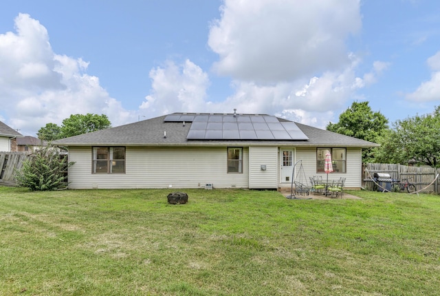 676 E Gallup Hill Rd, Nixa, MO 65714 - back of house with roof mounted solar panels, a fenced backyard, a patio, and a fire pit