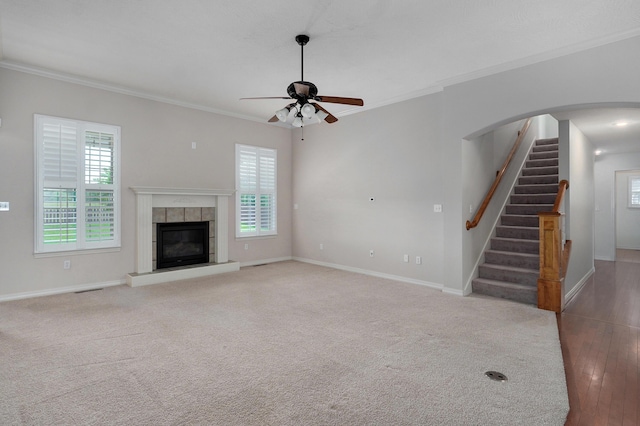 276 Steury Rd, Springfield, MO 65809 - unfurnished living room featuring plenty of natural light, crown molding, a ceiling fan, stairway, and a tile fireplace