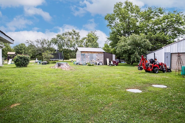 1950 N Crossway Rd, Fair Grove, MO 65648 - view of grassy yard with a trampoline, an outdoor structure, and a garage